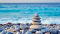 Et tårn af stablede sten står på en stenet strand.