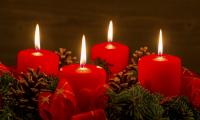 Stemningsfuldt billede med adventskrans med fire tændte røde stearinlys