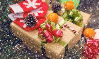 En bunke juleagtige ting på et bord, fx julegaver, grankogler, stribet bolsjestang, clementiner - og henover billedet er et sne-glimmer skær. 