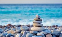 Et tårn af stablede sten står på en stenet strand.