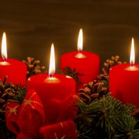 Stemningsfuldt billede med adventskrans med fire tændte røde stearinlys