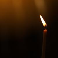 Stearinlys med ild i, flammen blafrer lidt. 